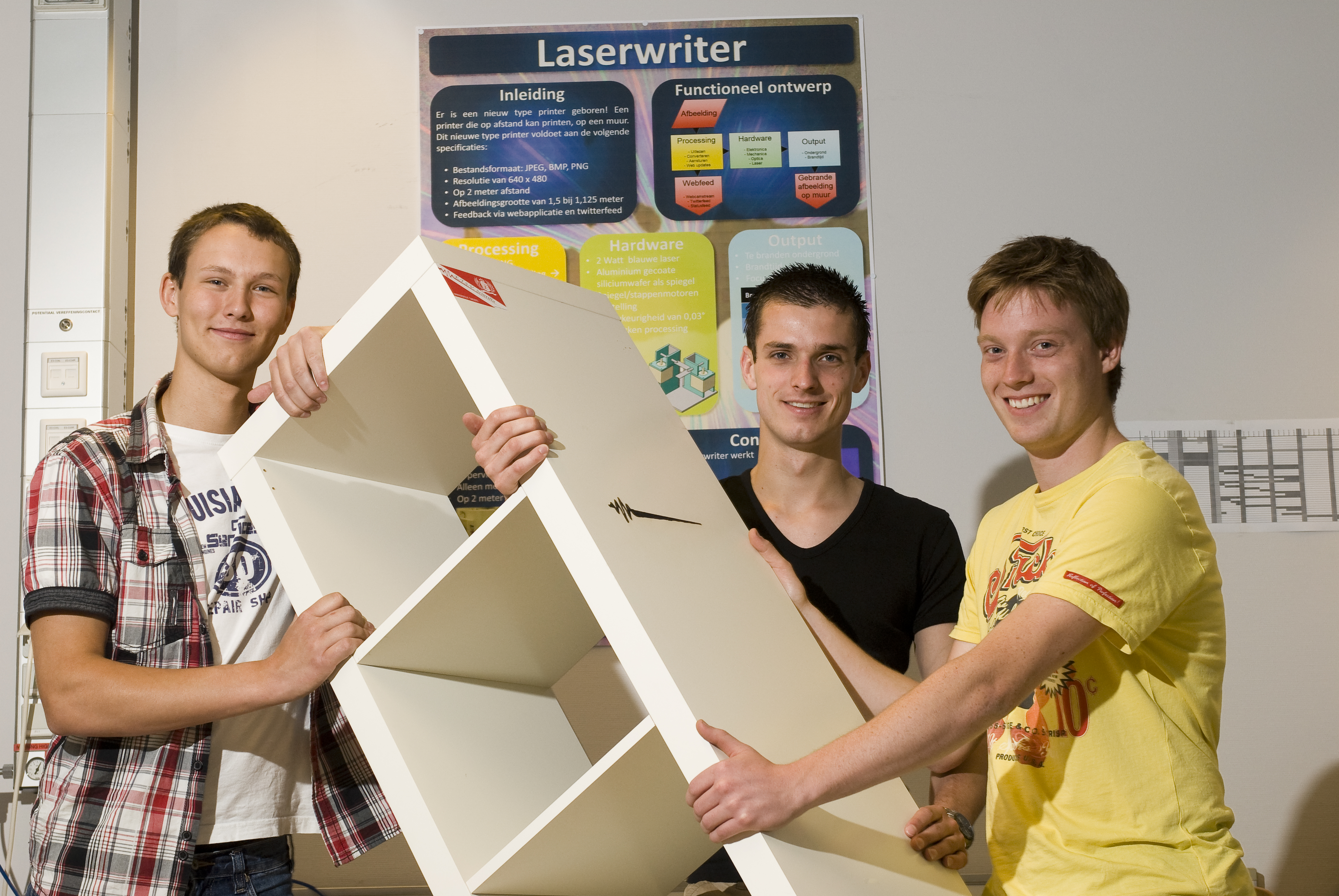 Een kast met een ingebrand Scintilla logo. V.l.n.r. Bob van de Vijver, Niels Middelhuis en Nico van Ginkel.